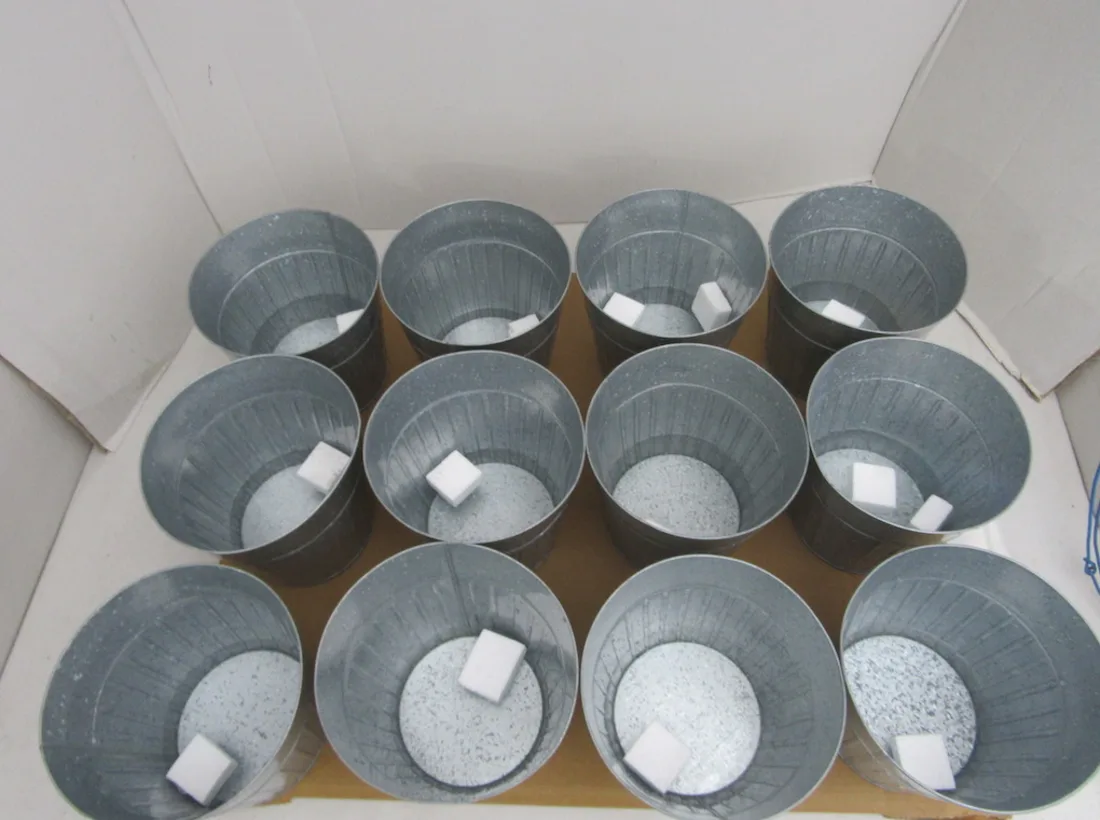 Galvanized planters arranged with protective packing material