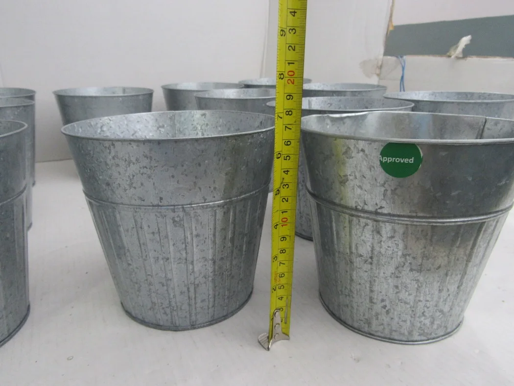 Tape measurement check on galvanized metal planters during production inspection