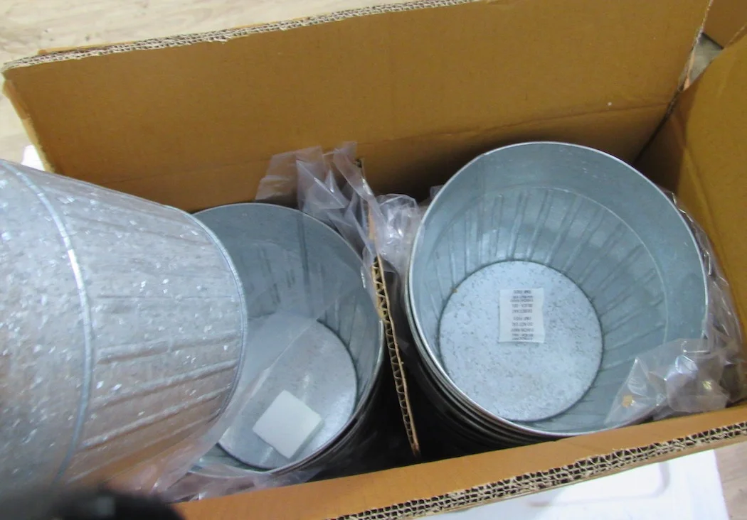 Galvanized planters nested with protective packing inside an export carton